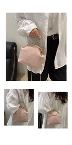 Detail of light pink vintage frame bag with textured dotted fabric and gold metal chain