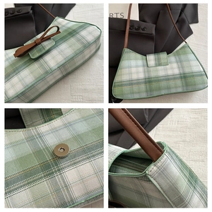 Close-up of green checkered canvas bag with leather strap and magnetic snap closure