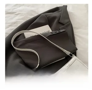 Detailed view of cream crocodile texture shoulder bag with a silver metallic bow accent