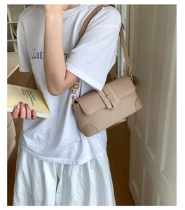 Detail of beige woven fabric and smooth leather patchwork on a stylish shoulder bag