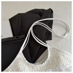 Nahaufnahme eines weißen Spitzen-Tops mit geometrischem Blumenmuster und Trägern