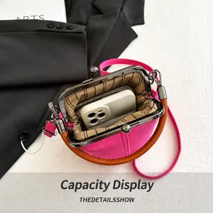 Interior view showing the capacity of pink kiss-lock denim handbag with a phone