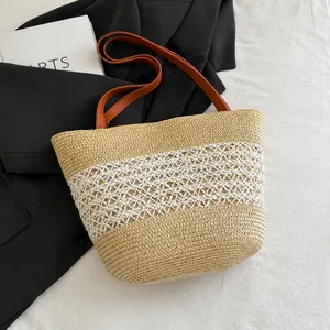 Detail of straw woven tote bag featuring hollow mesh pattern and brown leather handle