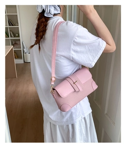 Pink vintage French shoulder bag with woven texture and adjustable strap on a model