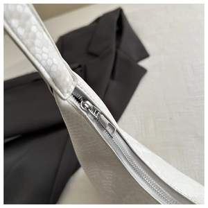 Detail of white faux snakeskin shoulder bag showing premium silver zipper closure