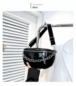 Detail of black glossy leather waist bag with silver chain and contrast strap