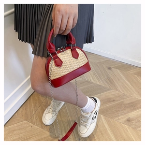 Détail du mini sac coquillage bicolore en rouge et paille avec bandoulière chaîne