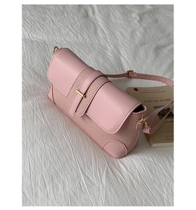 Dettaglio della borsa rosa con trama intrecciata e fibbia dorata per un look chic