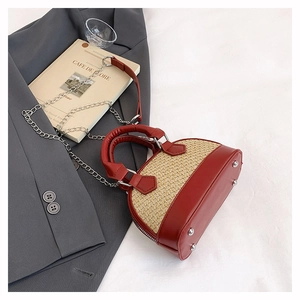 Détail du sac coquillage montrant le cuir rouge, le tissage et les pieds en métal argenté