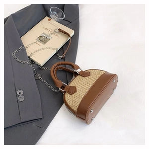 Détail du mini sac coquillage en paille avec chaîne argentée et pieds en métal