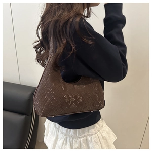 Detail of dark brown snakeskin embossed hobo bag with sleek retro moon shape design