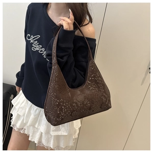 Detailed side view of deep brown snake skin pattern hobo shoulder bag worn by a model