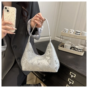 Detail of silver snake-embossed leather hobo bag with a metallic finish and shoulder strap