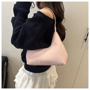 Detail of light pink snake skin textured tote bag with metal feet and slim shoulder strap