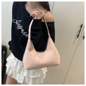 Detailed macro shot of pink faux snake skin texture on a stylish half moon shoulder bag