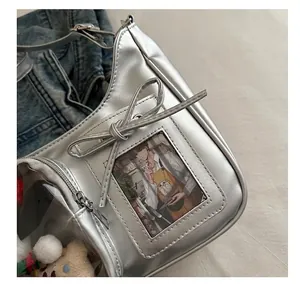 Details der silbernen Metallic-Tasche mit Schleifendekor und transparentem Kartenfach