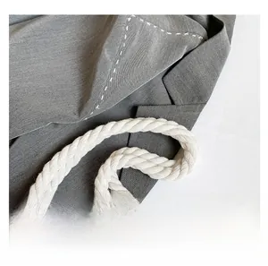 Detail of grey woven tote bag featuring twisted white cotton rope handles and suit collar design