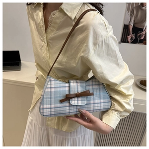 Detail der karierten Achseltasche in Blau und Rosa mit brauner Schleife und Lederriemen