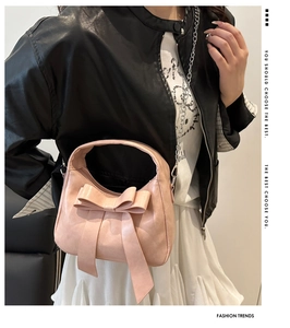 Dettaglio borsa rosa con fiocco in pelle PU e tracolla a catena argentata