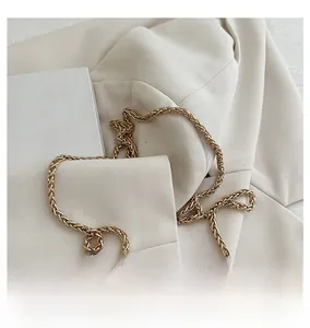 Close-up of golden braided metal chain strap for women's crossbody bucket bag
