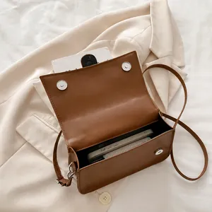 Internal storage of brown leather crossbody bag showing capacity for phone and wallet