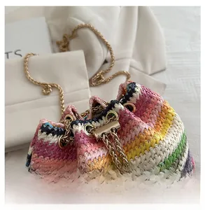 Detail of premium gold hardware drawstring and chain on rainbow woven bucket bag