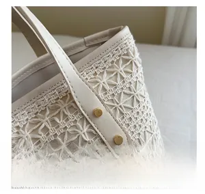 Detailed close-up of ivory crochet tote bag with lace pattern and leather rivet strap
