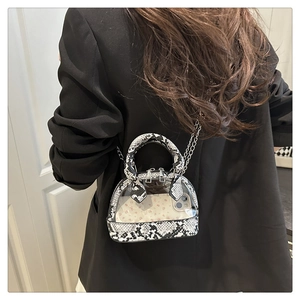 Detailansicht der Mini-Muscheltasche mit PVC-Panel und Schlangenleder-Strukturakzenten