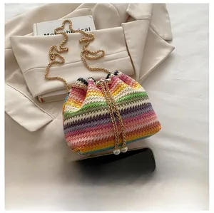 Detail of woven bucket bag featuring colorful stripes and dual pearl drawstring accents