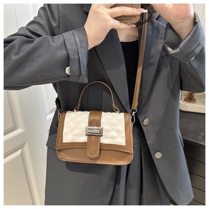 Detail of a quilted small crossbody bag with metal buckle on a grey suit model