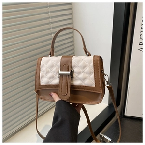 Détail du sac bandoulière matelassé avec bordure en cuir marron et boucle en métal
