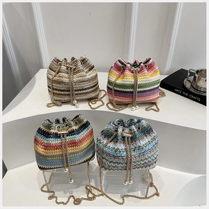 Detailed view of woven bucket bags with pearl drawstrings and golden chain straps