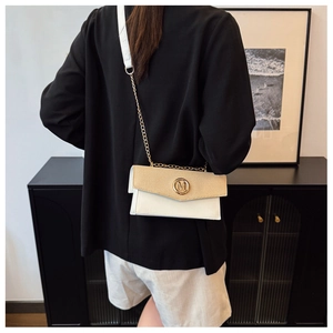 Close-up of beige woven texture and white leather flap with golden M logo hardware