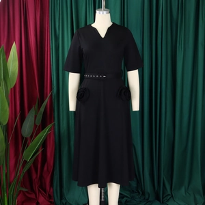 Detail of V-neck black dress featuring handmade 3D rose pockets and waist belt