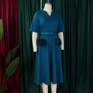 Detailed view of dark teal V-neck dress with decorative rose accents and waist belt