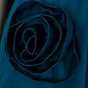 Close-up of deep teal 3D floral fabric decoration with intricate layered edging