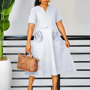 Detail showing the light blue V-neck dress with unique 3D rose-shaped pockets and waist belt