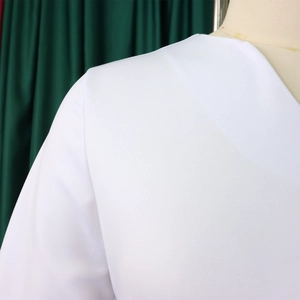 Detail shot of the V-neckline and fabric texture of this elegant white A-line dress