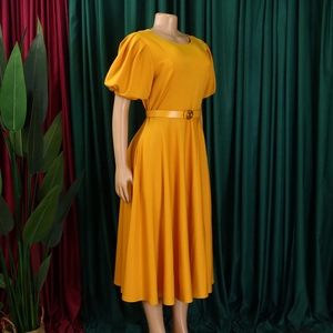 Close-up of mustard yellow puff sleeves and waist belt with golden buckle detail
