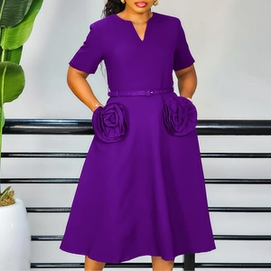 Detail of dark purple dress featuring 3D rose ornaments and matching waist belt
