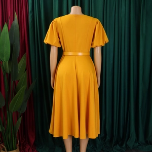 Back view of elegant ginger yellow A-line dress with puff sleeves and waist belt detail