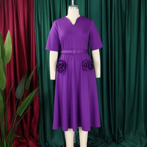 Detail view of purple V-neck dress featuring handmade fabric roses and matching fabric belt