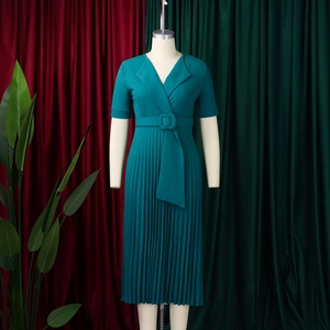 Detail of teal V-neck pleated dress with matching belt and buckle on a mannequin