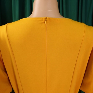 Detail view of a bright yellow dress featuring a high-quality invisible back zipper