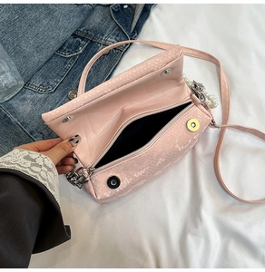 Dettaglio borsa a scatola rosa motivo serpente con catena di perle e scomparto zip
