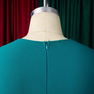 Detail of teal maxi dress showing invisible back zipper and premium pleated fabric texture