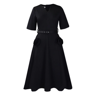 Detail of V-neckline and waist belt with metallic buckle on this black A-line midi dress