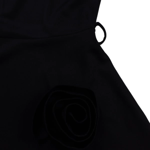 Close-up of black A-line dress featuring waist tailoring and 3D fabric rose detail