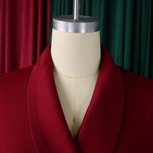 Detail van bordeauxrode blazer met revers en subtiele verticale streeptextuur op een mannequin