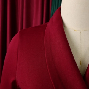 Macro-opname van de bordeauxrode blazerhals met fijne keperstof en schouderdetails